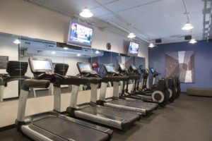 Fitness center in the downtown Chicago hotel with treadmills and ellipticals in front of a mirror with tv's hung on the wall