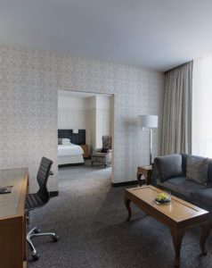 Suite with desk and roll chair near sofa and coffee table at Hotel Chicago Downtown, Autograph Collection