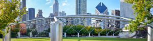 Jay Pritzker Pavilion in Millennium Park, Chicago, with nearby hotel accommodations and city activities set against modern skyscrapers on a sunny day.