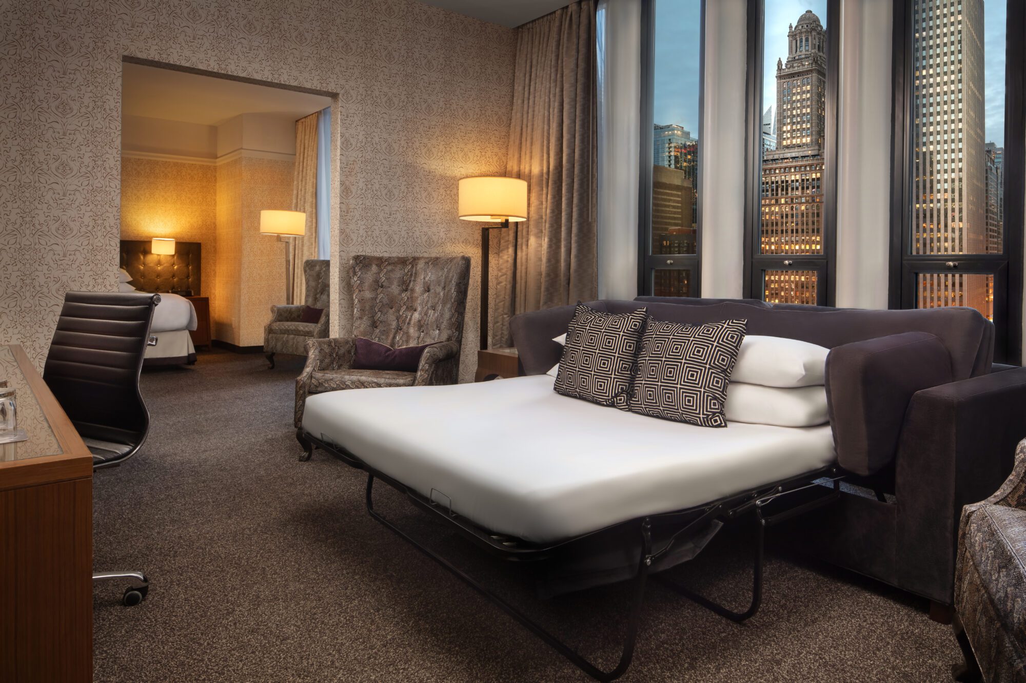 Pull out sofa bed with pillows near desk overlooking buildings at Hotel Chicago Downtown, Autograph Collection
