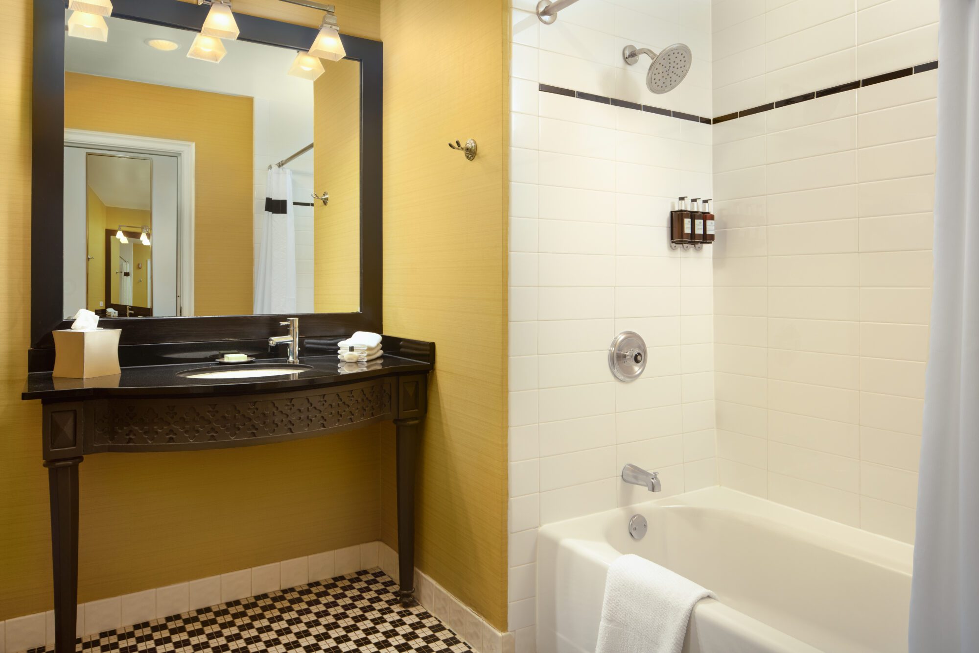 Bathroom with yellow walls and bathtub in front of mirror at Hotel Chicago Downtown, Autograph Collection