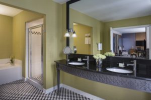 Bathroom with black and white tiles and yellow walls in front of mirror at Hotel Chicago Downtown, Autograph Collection