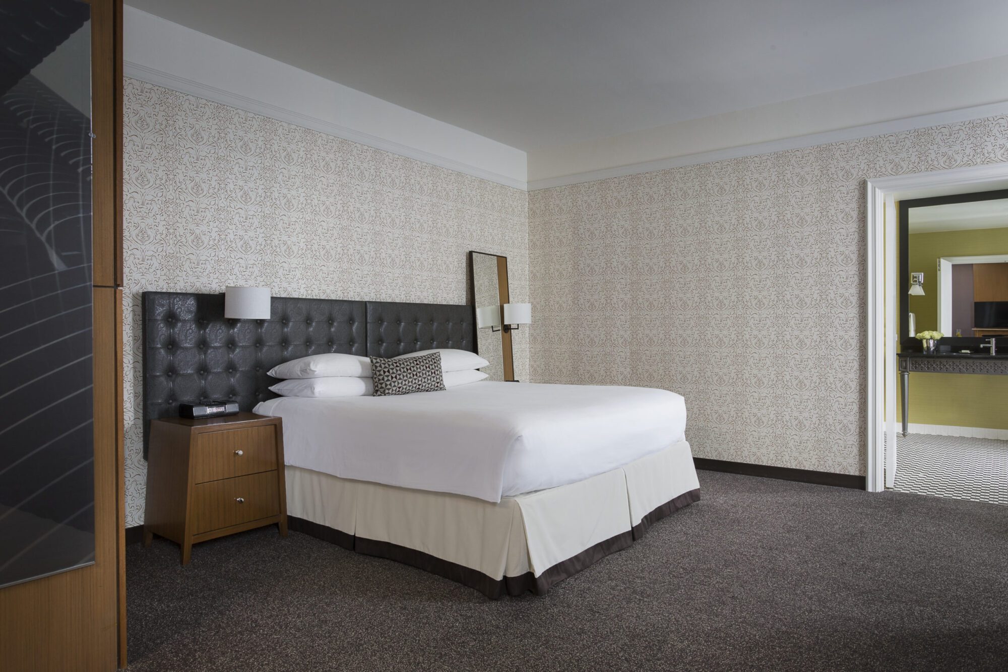 Large bed with white linens in front of black headboard at Hotel Chicago Downtown, Autograph Collection