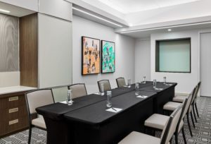 Meeting room set with black linened tables, water bottles and ben and paper in downtown Chicago hotel