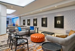 Prefunction space with seating with grey sofas and modern art on the walls at Hotel Chicago Downtown, Autograph Collection