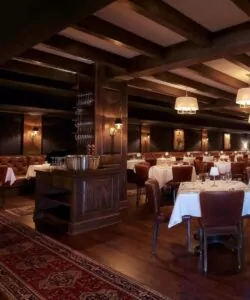 Elegant restaurant with wooden beams and white tablecloths offers refined dining and entertainment in a top hotel Chicago setting.